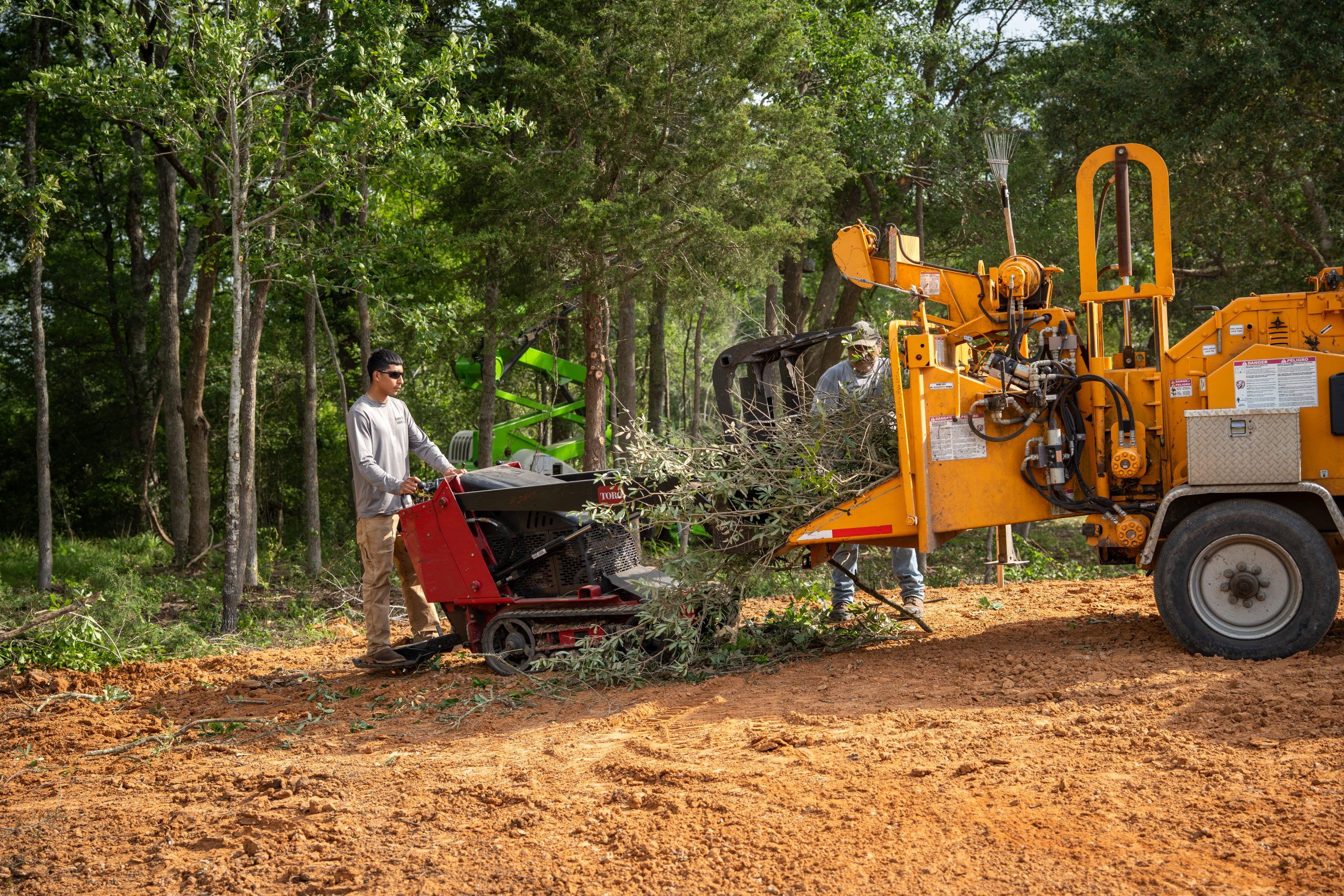 A tree stump grinding machine operating in a grassy outdoor area.